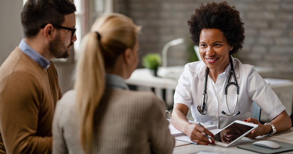 Médica de seguro saúde empresarial apresentando resultado de exame para funcionários de uma empresa