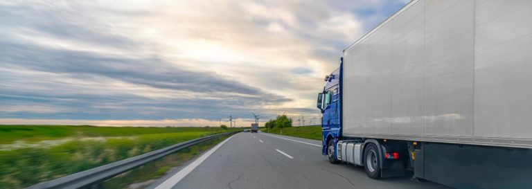 Caminhão de carga em rodovia, representando a importância da declaração correta do valor segurado no transporte